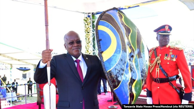 Le président John Magufuli, tient une lance et un bouclier reçus des chefs traditionnels après avoir prêté serment pour son second mandat au stade Jamhuri de Dodoma, en Tanzanie, le 5 novembre 2020.