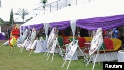 Flag-draped caskets of seven children who were killed by unidentified assailants in a classroom of a secondary school are pictured during their mass funeral in Kumba, Cameroon, Nov. 5, 2020.