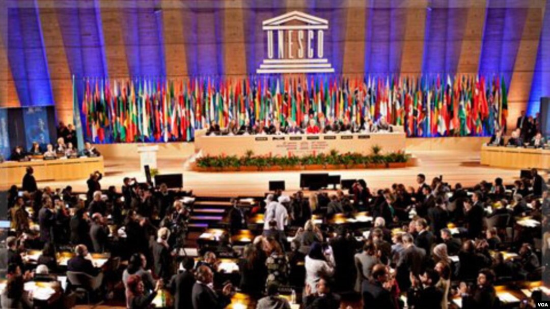 Para delegasi bersorak-sorai setelah hasil pemungutan suara, 107-14, meloloskan permohonan Palestina menjadi anggota penuh UNESCO, Senin (31/10).