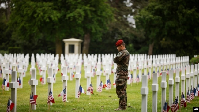 A soldier stands by headstones at the American Cemetery during a ceremony to mark the 79th anniversary of the assault that led to the liberation of France and Western Europe from Nazi control, in Colleville-sur-Mer, Normandy, France, Tuesday, June 6, 2023. The American Cemetery is home to the graves of 9,386 United States soldiers. Most of them lost their lives in the D-Day landings and ensuing operations. (AP Photo/Thomas Padilla)