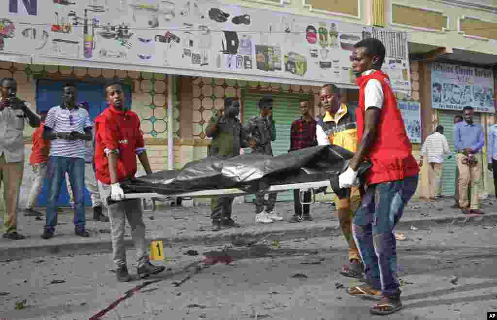 Des travailleurs médicaux enlèvent le corps d&#39;un civil tué dans une explosion d&#39;une voiture piégée près du Parlement, à Mogadiscio, en Somalie, le 25 mars 2018.