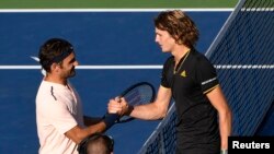 Petenis Swiss Roger Federer (kanan) berjabat tangan dengan petenis Jerman Alexander Zverev. Zverev mengalahkan Federer dengan skor 6-3 and 6-4 dalam final Piala Rogers di Uniprix Stadium, Montreal