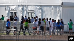 FILE - Children line up to enter a tent at a shelter for migrant children in Homestead, Fla., Feb. 19, 2019. A Biden administration effort to reunite children and parents separated under then-President Donald Trump's zero-tolerance border policy has made increasing progress.