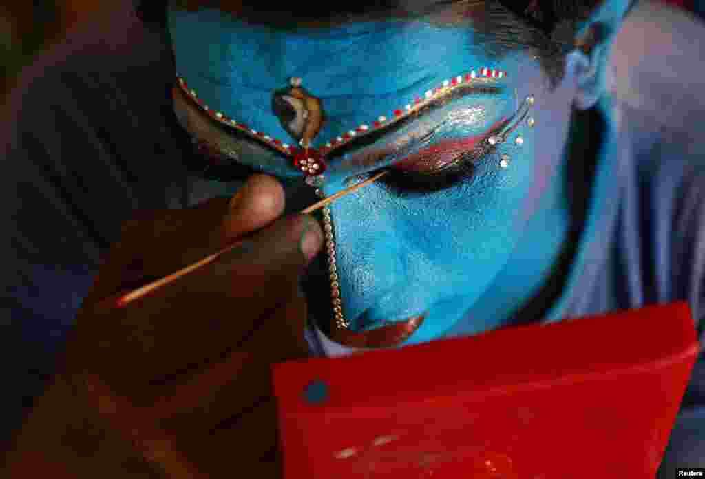 A man gets ready backstage before performing in the 34th Cochin Carnival which is held annually to welcome the start of the New Year at Fort Kochi in the southern state of Kerala, India, Jan. 1, 2018.