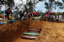 FILE - Relatives mourn at the site of a mass burial at the Nossa Senhora Aparecida cemetery, in Manaus, Amazonas state, Brazil, April 21, 2020.