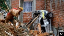 A volunteer searches for people in the rubble after heavy rain triggered a landslide in Franco da Rocha, Sao Paulo state, Brazil.