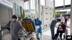 Enfermeras y pacientes en la entrada de emergencia del hospital privado Ricardo Palma, en Lima, Perú, en medio de la pandemia de COVID-19. Julio 7 de 2020.