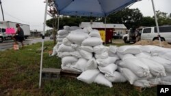 A man, far left, sells sandbags as Hurricane Isaias approaches, in Wilmington, North Carolina, Aug. 3, 2020.