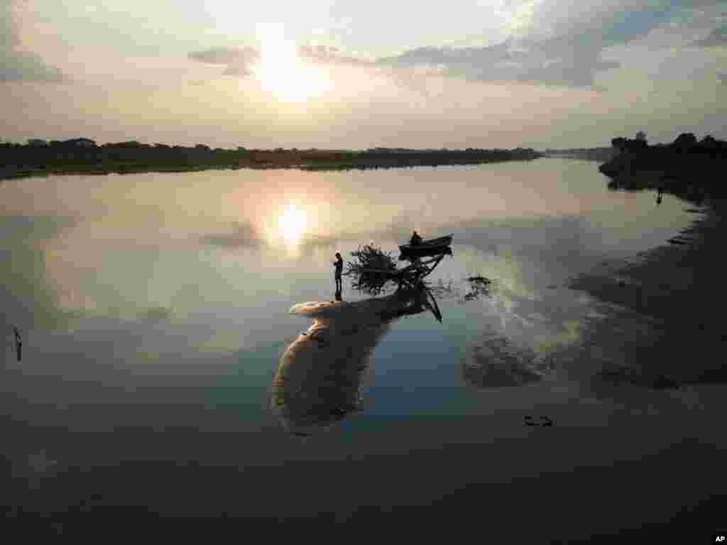 Men fish on the shore of the Paraguay River during the seventh week of the government's lockdown to prevent spread of the new coronavirus, in Lambare, Paraguay, April 30, 2020.