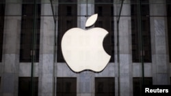 FILE - An Apple logo hangs above the entrance to the Apple store on 5th Avenue in the Manhattan borough of New York City, July 21, 2015. 