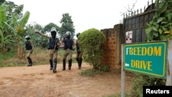 FILE - Ugandan police officers order journalists to leave a road leading to the home of Ugandan opposition presidential candidate Robert Kyagulanyi, also known as Bobi Wine, in Kampala, Jan. 16, 2021. 