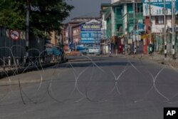 A barbwire blocks a deserted street on the first anniversary of India’s decision to revoke the disputed region’s semi-autonomy, in Srinagar, Indian controlled Kashmir, Aug. 5, 2020.