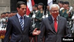 Presiden Meksiko Enrique Pena Nieto (kiri) menyambut tamunya Presiden Singapura, Tony Tan Keng Yam dalam upacara kehormatan di Mexico City, Jumat (10/6).