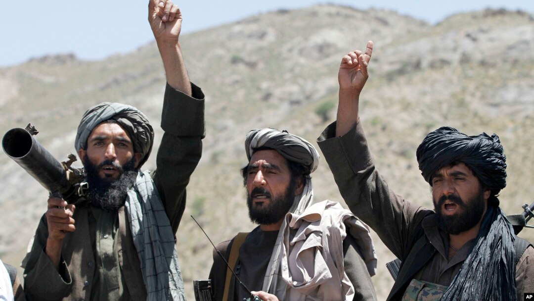 FILE - In this May 27, 2016, photo, Taliban fighters react to a speech by their senior leader in the Shindand district of Herat province, Afghanistan.