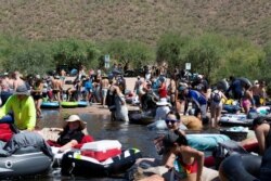 FILE - People prepare to go tubing on Salt River amid the outbreak of the coronavirus pandemic, in Arizona, June 27, 2020.