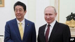 아베 신조 일본 총리와 블라디미르 푸틴 러시아 대통령이 22일 모스크바 크렘린궁에서 회담에 앞서 악수하고 있다. 