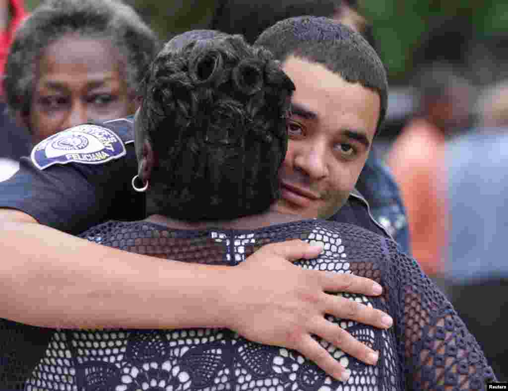 A police officer is embraced after a vigil for the fatal attack on Baton Rouge policemen, at Saint John the Baptist Church in Zachary, Louisiana, July 17, 2016. 