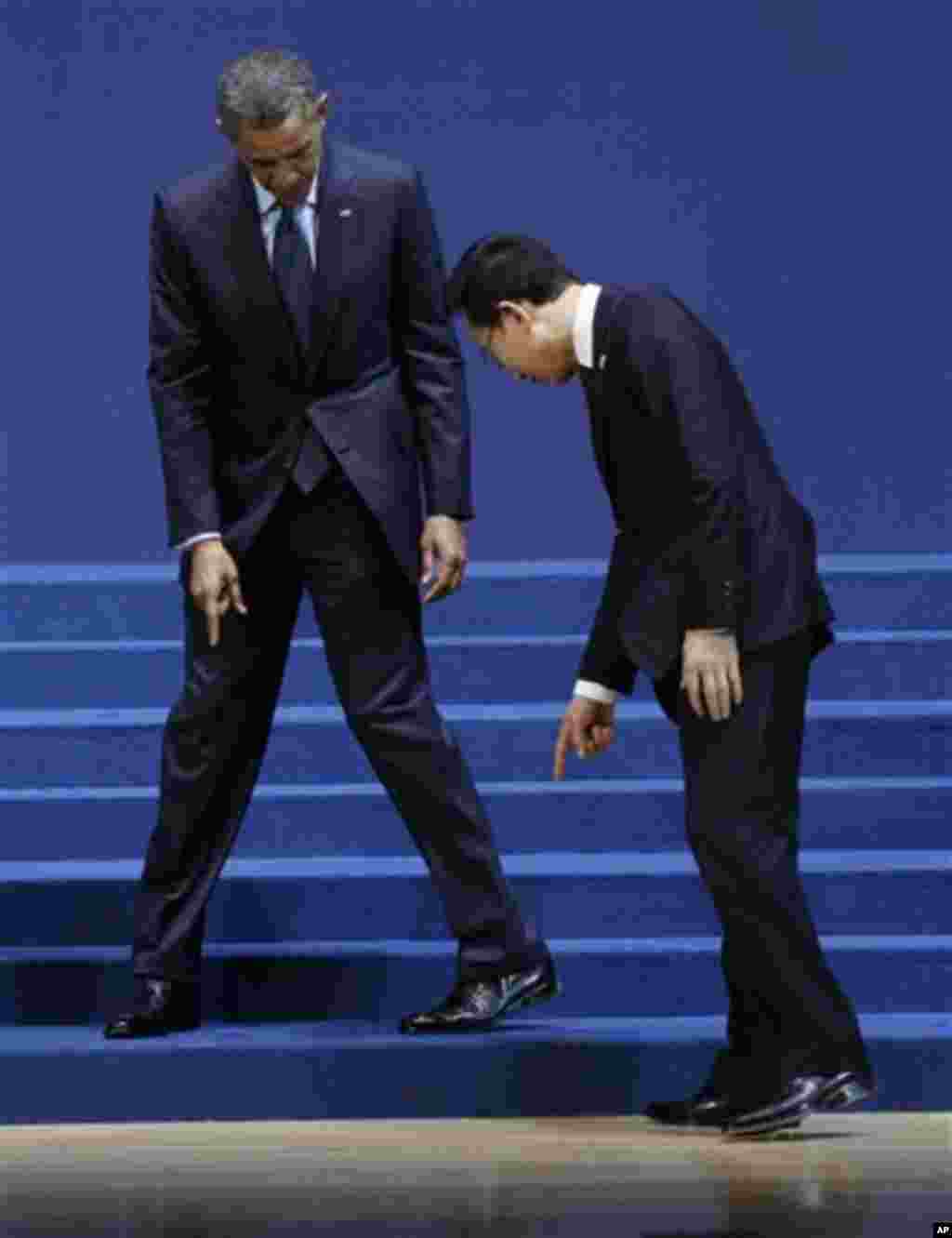 U.S. President Barack Obama and South Korean President Lee Myung-bak, look for their marked positions on the floor as they arrive for a group photo session for the Nuclear Security Summit in Seoul, South Korea, Tuesday, March 27, 2012. (AP Photo/Pablo Mar