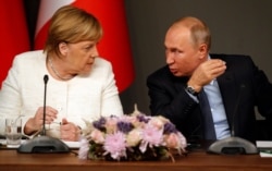 FILE - German Chancellor Angela Merkel, left, listens to Russian President Vladimir Putin as they attend a news conference following a summit on Syria, in Istanbul, Oct. 27, 2018.