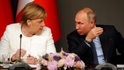German Chancellor Angela Merkel, left, listens to Russian President Vladimir Putin as they attend a news conference following a summit on Syria, in Istanbul, Oct. 27, 2018.