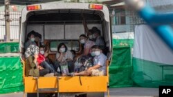 Buruh migran dan keluarganya naik truk sambil menunggu dirawat di rumah sakit khusus untuk perawatan pasien COVID-19, di Samut Sakhon, Selatan Bangkok, Thailand, Senin 4 Januari 2021.