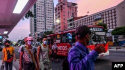 ရန်ကုန်မြို့ ဘတ်စ်ကားမှတ်တိုင်တခုအနီး နှာခေါင်းစည်းတပ် သွားလာနေသူအချို့။ (မေ ၁၅၊ ၂၀၂၀)
