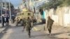 FILE - African Union Mission to Somalia (AMISOM) soldiers carry the wreckage of a vehicle at the scene of suicide bombing that targeted AMISOM forces in Mogadishu, Somalia, on Nov. 11, 2021.