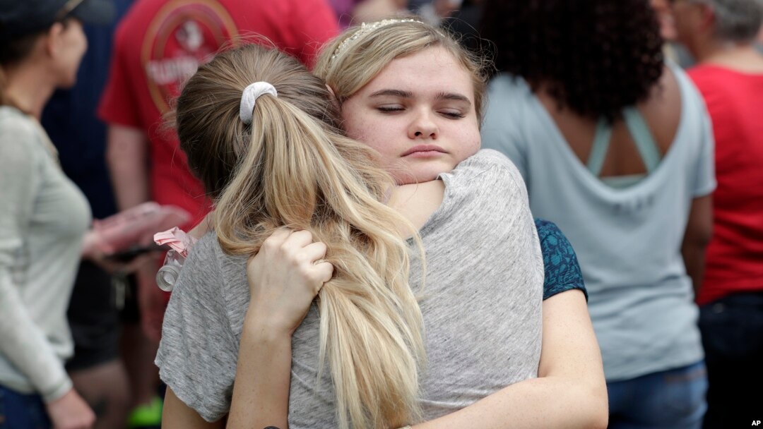 Students hug outside a staging area at the First Baptist Church of Ocala as parents arrive to pick them up after a shooting incident at nearby Forest High School in Ocala, Florida, April 20, 2018.