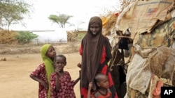 A Somali refugee woman stands with her children outside their makeshift shelter at the Dagahaley camp in Dadaab, near the Kenya-Somalia border, (File)