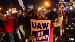 密歇根州韦恩市福特汽车装配厂街对面，美国汽车工人联合会的成员举着标语维持罢工纠察线。（2023年9月15日）
