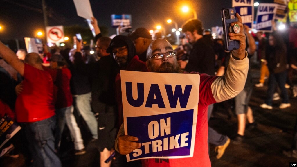 Members of the UAW (United Auto Workers) picket and hold signs outside of the UAW Local 900 headquarters across the street from the Ford Assembly Plant in Wayne, Michigan on September 15, 2023.