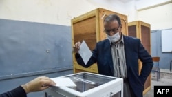 An Algerian man casts his ballot at a polling station in the capital Algiers during a vote for a revised constitution, Nov. 1, 2020. 