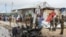 Security forces stand next to wreckage at the scene of a suicide car bomb attack in the capital Mogadishu, Somalia, July 13, 2020.
