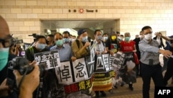 In this file photo taken on Nov. 3, 2020 pro-democracy activists demonstrate outside the West Kowloon court in Hong Kong. The United States on July 16, 2021, imposed sanctions on seven more officials accused of curbing freedoms in Hong Kong.