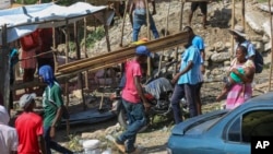 FILE - Residents of the Nazon neighborhood displaced by gang violence construct a tent encampment, in Port-au-Prince, Haiti, Nov. 15, 2024.