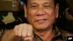 Philippine President Rodrigo Duterte, sen in this Aug. 25, 2016, gestures with a fist bump during his visit to the Philippine Army's Camp Mateo Capinpin at Tanay township, Rizal province east of Manila, Philippines. The Philippine president has apologized