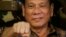 Philippine President Rodrigo Duterte, sen in this Aug. 25, 2016, gestures with a fist bump during his visit to the Philippine Army's Camp Mateo Capinpin at Tanay township, Rizal province east of Manila, Philippines. The Philippine president has apologized