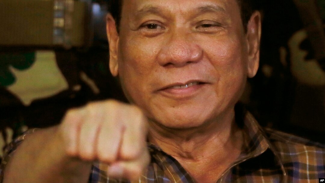 Presiden Filipina Rodrigo Duterte menyorongkan tinju dalam kunjungan ke Kamp Militer Mateo Capinpin di Tanay, provinsi Rizal, timur Manila (25/8). (AP/Bullit Marquez)