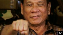 Presiden Filipina Rodrigo Duterte menyorongkan tinju dalam kunjungan ke Kamp Militer Mateo Capinpin di Tanay, provinsi Rizal, timur Manila (25/8). (AP/Bullit Marquez)