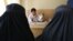 FILE - An Afghan mental health doctor, center, talks with patients in the Mental Health and Drug Addicts' Hospital in Kabul, Afghanistan, July 17, 2016.