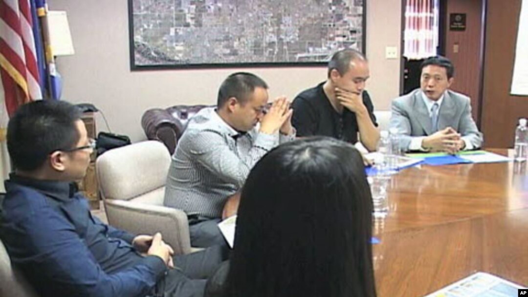 Investors from China meet in a conference room to discuss investment opportunities, green cards and other pertinent issues, in Lancaster, California, September 2011.