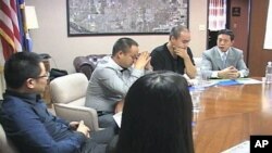 Investors from China meet in a conference room to discuss investment opportunities, green cards and other pertinent issues, in Lancaster, California, September 2011.