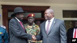 Le président du Soudan du Sud, Salva Kiir, à gauche, et le chef de l'opposition Riek Machar, à droite, se serrent la main après les réunions du 20 octobre 2019.