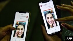 Women view a tweet posted by Lina, the sister of Saudi activist Loujain al-Hathloul, showing a screenshot of them having a video call following Hathloul's release after nearly three years in detention, Riyadh, Feb. 10, 2021.