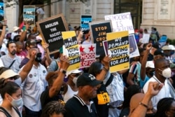 Demonstrators hold signs during a march for voting rights, marking the 58th anniversary of the March on Washington, Aug. 28, 2021, in Washington.