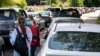 Voluntarios en Annandale, Virginia, se colocan entre cientos de automóviles para registrar a las personas que se alinean para las pruebas de COVID-19, el sábado 23 de mayo de 2020. 