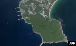 FILE - This August 18, 2020, image courtesy of Planet Labs Inc. reportedly shows a Chinese submarine (center, bottom) entering an underground base on Hainan Island on the South China Sea.