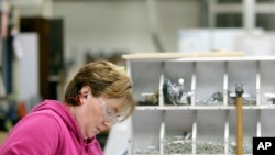 FILE - A worker builds shelves for an Airstream travel trailer at the Airstream factory, in Jackson Center, Ohio, Oct. 22, 2014. 