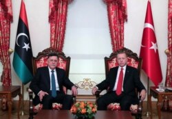 FILE - Turkey's President Recep Tayyip Erdogan, right, meets with Fayez al Sarraj, left, the head of Libya's internationally-recognized government, prior to their meeting in Istanbul, Nov. 27, 2019.