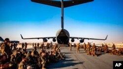 Los infantes de marina asignados a la 24ª Unidad Expedicionaria de la Infantería de Marina esperan un vuelo a Kabul, Afganistán, en la Base Aérea Al Udeied, Qatar, el 17 de agosto del 2021.